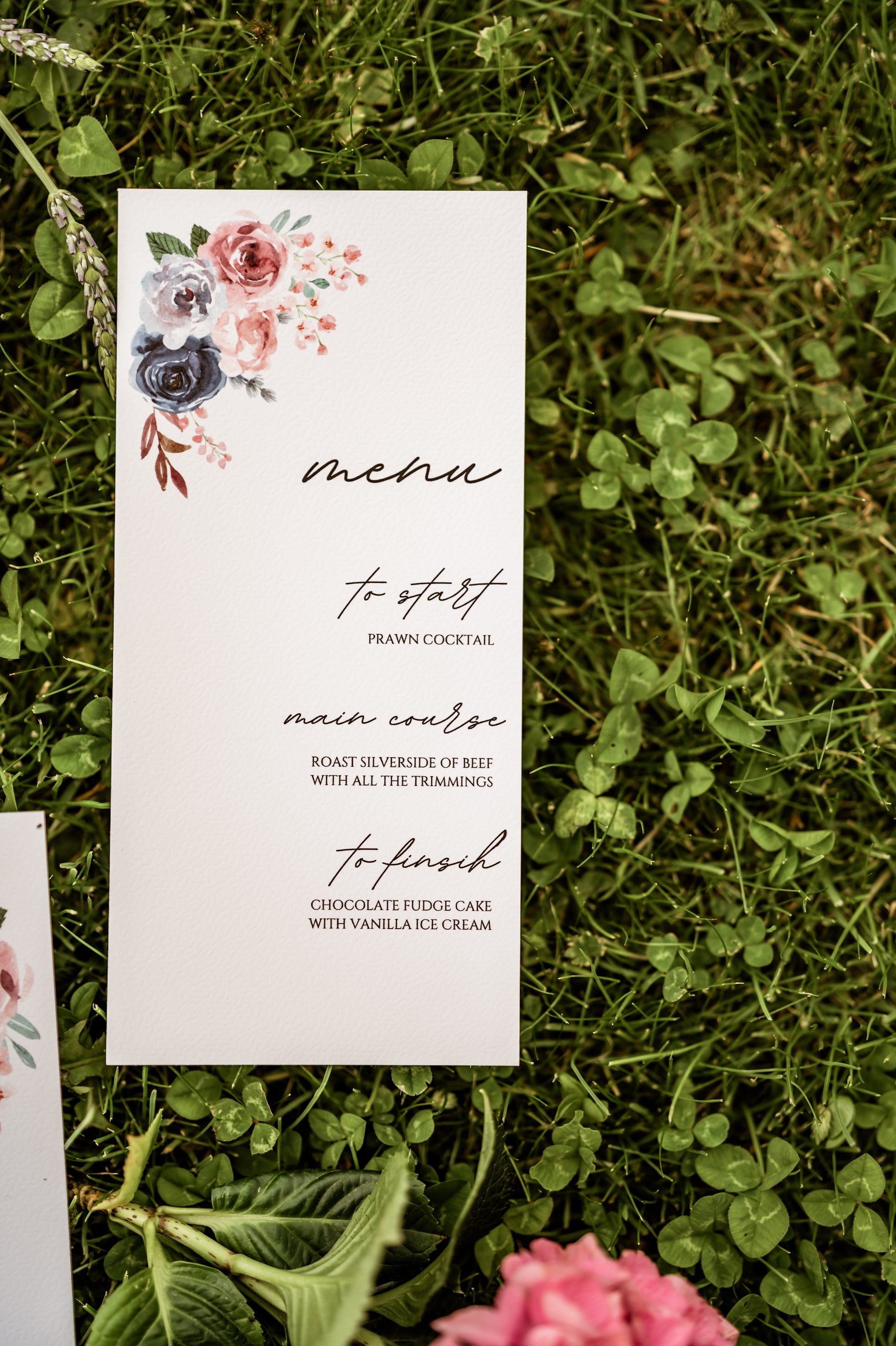 Menu card with floral design on grass